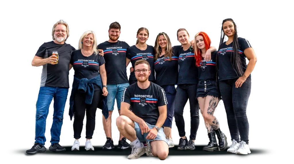Das Biker Land Team steht lächelnd in schwarzen T-Shirts, umgeben von einer freundlichen Atmosphäre.